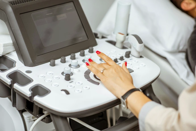 A woman using an ultrasound control panel